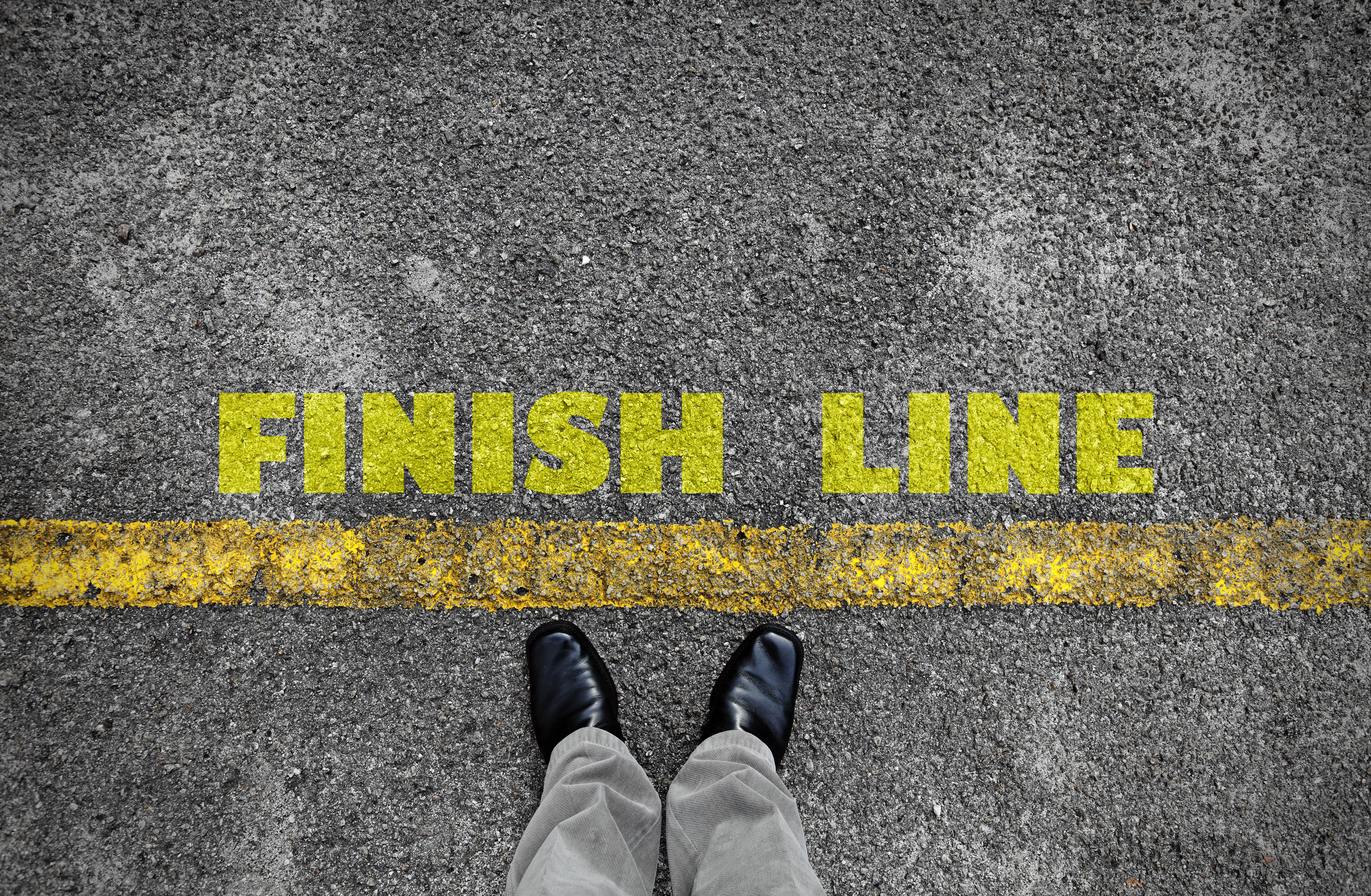 Finish line written in yellow text on a roadway Finish line written in yellow text on a roadway